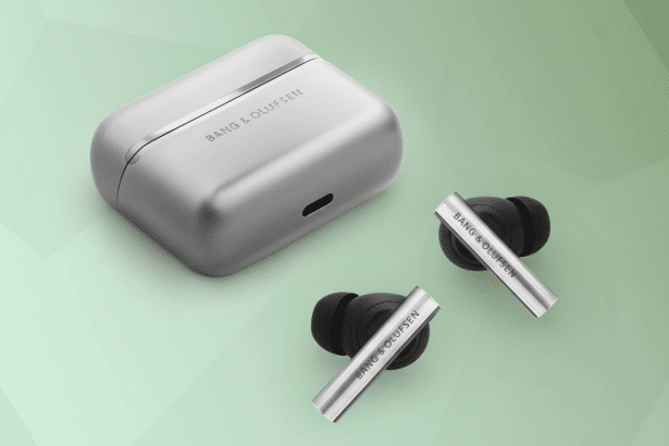 A professional shot of Bang & Olufsen earbuds and their charging case on a subtly patterned green background. Filename : bangol ufsenear buds. png