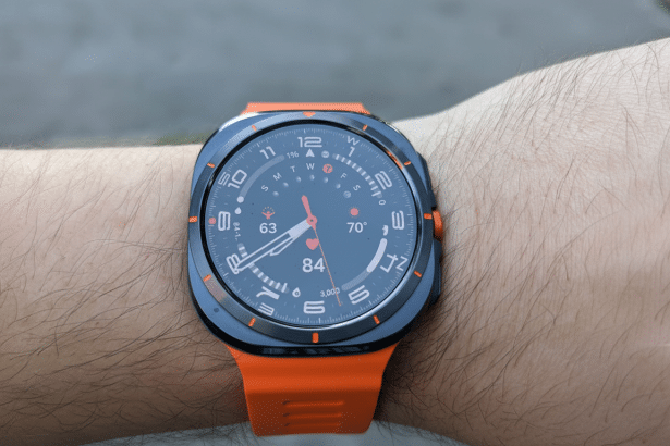 A close-up of a smartwatch with an orange band on a person s wrist, showing various health metrics and the time.
