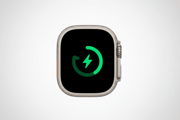 An Apple Watch Ultra displaying a green charging icon on a black screen, set against a professional light grey background with a subtle gradient.