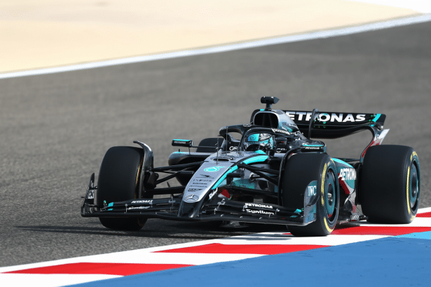 A professional shot of a Mercedes -AMG Petronas F1 car on a race track, featuring the driver in the cockpit, resized to a 1 6: 9 aspect ratio.