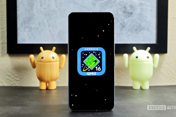 A smartphone displaying the Android 16 Q PR2 logo on a black screen, flanked by two Android figurines .