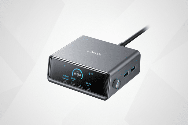 A professional shot of an Anker Prime 25 0W power bank with a digital display showing POWER 250 .0W and various charging ports , set against a soft, gradient background with subtle geometric patterns. Filename : anker prime25 0wpower bank.png