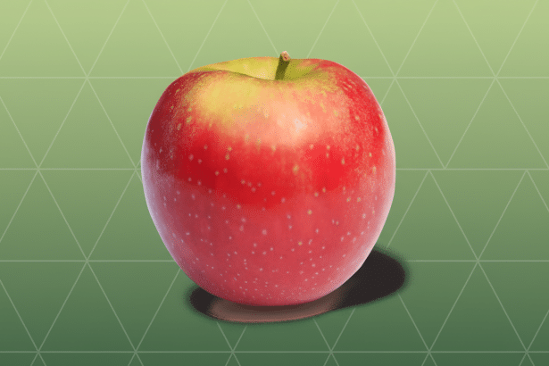 A professional shot of a red and yellow apple with a subtle green gradient and geometric pattern background.