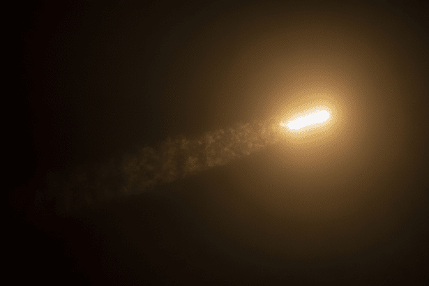 A rocket launching into a dark sky, leaving a bright trail of exhaust.