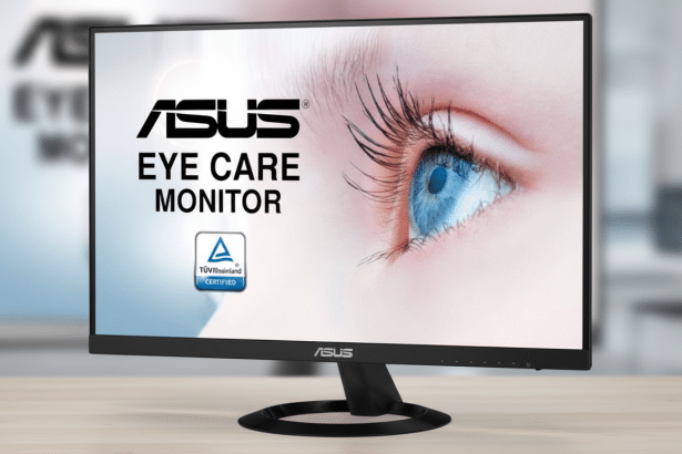 An ASUS Eye Care Monitor displayed at a 16 :9 aspect ratio , showing a close -up of a human eye with long lashes on its screen. The monitor sits on a light wooden surface with a slightly blurred office background. Filename : asus eyecare monitor16 9. png