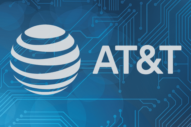 The AT &T logo, featuring a white globe icon and the text AT&T, against a blue background with a faint circuit board pattern.