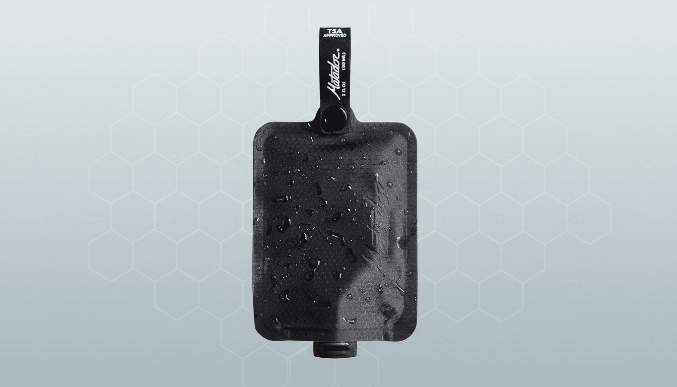 A black Matador TSA- approved travel pouch with water droplets on its surface, presented on a professional grey background with a subtle hexagonal pattern.