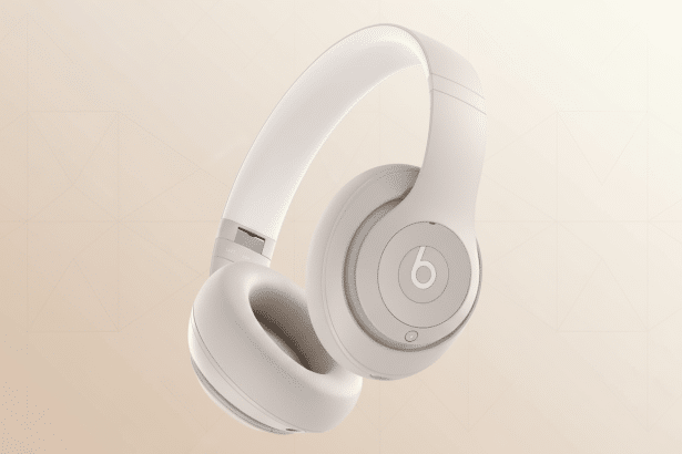 A pair of beige Beats Studio headphones shown from a slightly elevated angle against a soft , gradient background with subtle geometric patterns. Filename : beatsstudio headphonesbeige . png