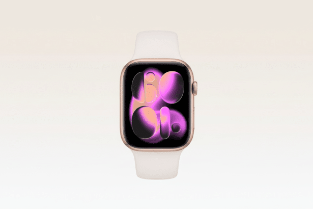 A gold Apple Watch with a white band is centered against a soft, light pink gradient background. The watch face displays an abstract design with purple and orange hues .