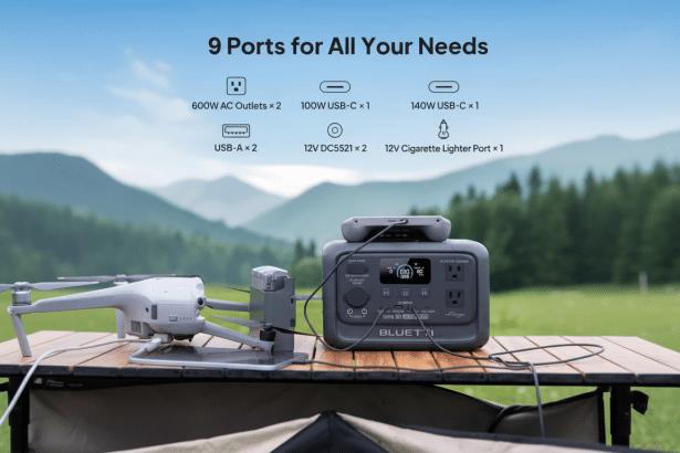 A grey portable power station on a wooden table outdoors , connected to a drone. Text above describes its 9 ports .
