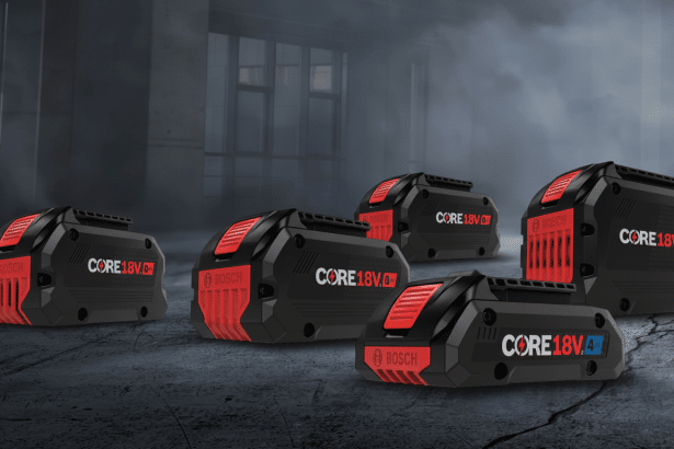 Five Bosch CORE1 8V batteries , featuring red and black casing with white text, are arranged on a dark, textured surface with a blurred industrial background .