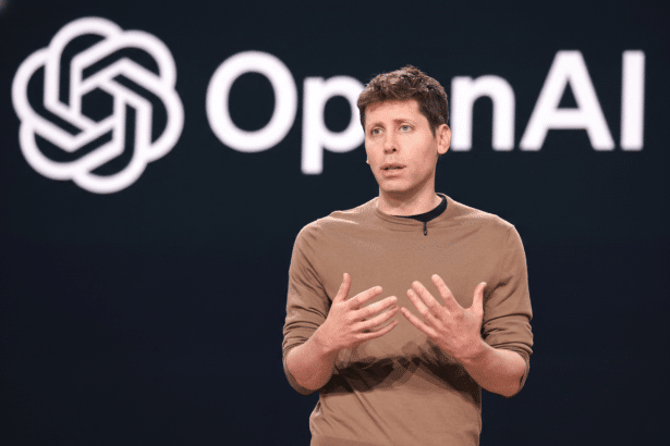 Sam Altman speaking on stage in front of the OpenAI logo.