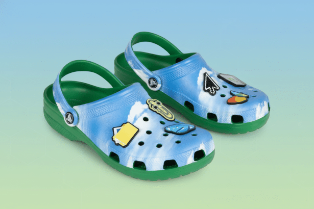 A pair of blue and green Crocs with various digital-themed charms , presented on a subtle gradient background with geometric patterns. Filename : crocs digitalchar ms.png