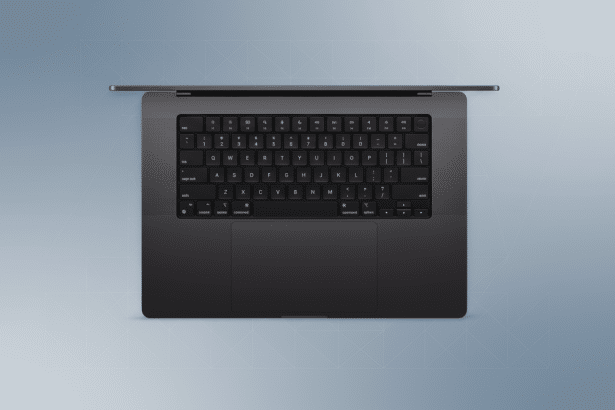 An overhead view of a dark gray laptop with a keyboard and trackpad, set against a subtle , light gray patterned background. Filename : dark graylaptop overhead .png