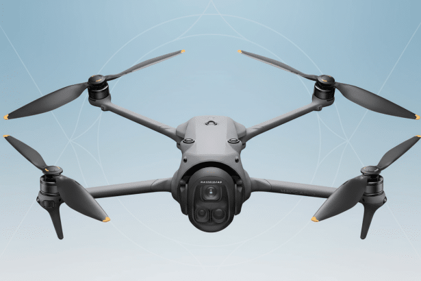 A professional shot of a gray DJI Mavic 3 drone with four propellers , centered against a light blue background with subtle geometric patterns .