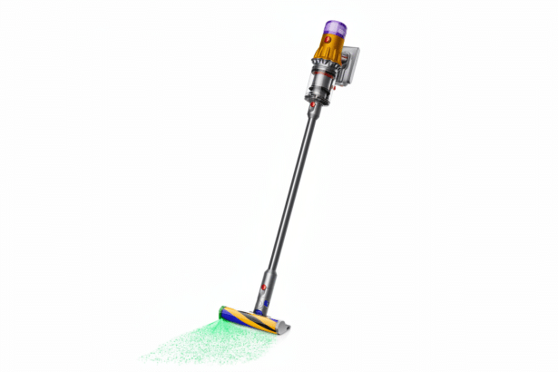 A Dyson V15 Detect Absolute cordless vacuum cleaner shown in use, with green laser light highlighting dust on a white background.
