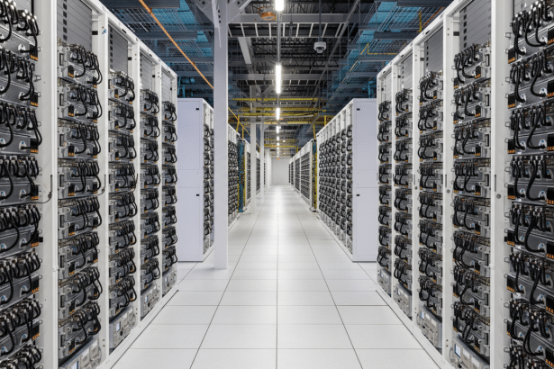 lt Text : A long corridor in a data center , lined on both sides with rows of server racks, under ov