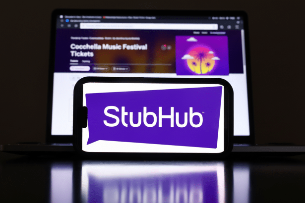 The Stub Hub logo is displayed on a smartphone screen, centered in front of a laptop showing the Coachella Music Festival website .