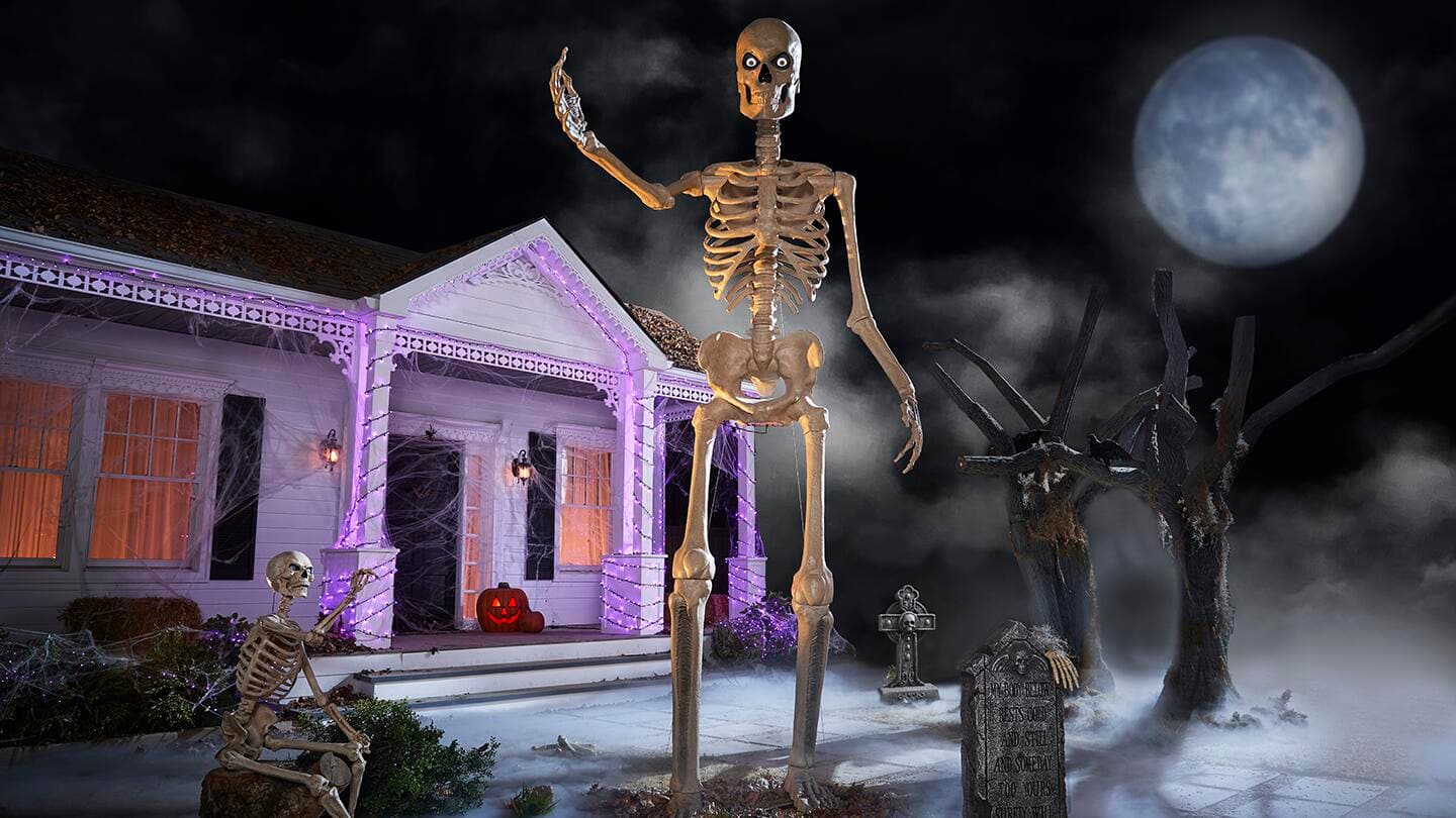 Halloween decor deals: store aisle with sale signs, pumpkins and skeletons