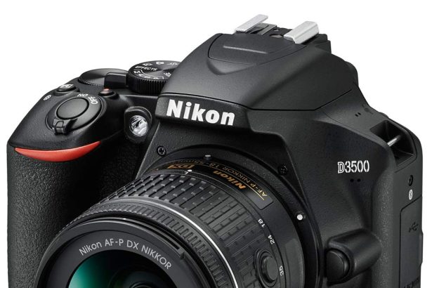 Entry-level DSLR camera with kit lens on desk for beginner photography