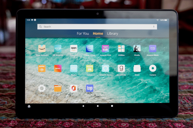 An Amazon Fire tablet displaying its home screen with various app icons , including Amazon Shop , Silk Browser, Appstore, Prime Video, Amazon Kids , Utilities, Kindle , Amazon Music, Audible, News, Photos , Games, Amazon Alexa, Goodreads, Email, Camera , Settings, Files , Office, and Warp Text.
