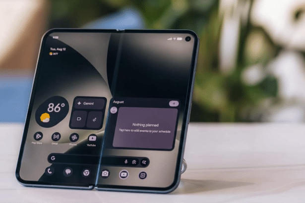 A modern foldable smartphone with a dual screen displaying widgets , placed on a white surface with a blurred green background. Filename : foldablesmartphone display widgets .png