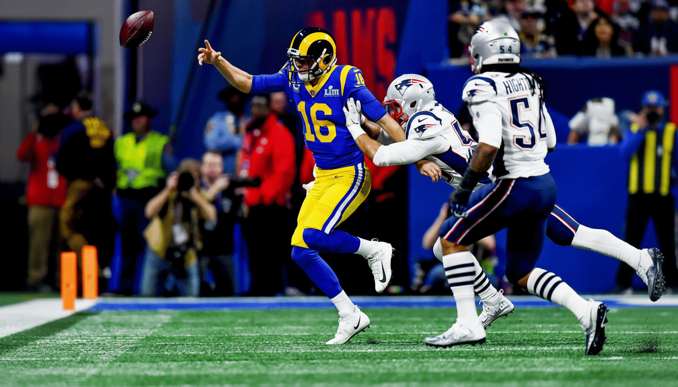 An American football player in a blue and yellow uniform, number 1 6, ev ades a tackle from a player in a white uniform, while another player in white