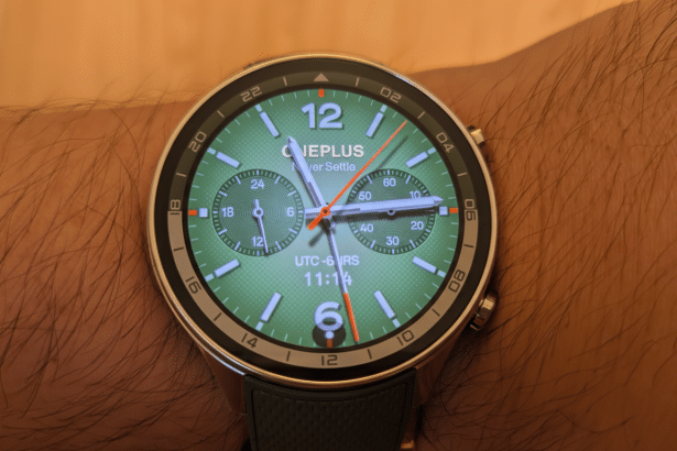 A professional shot of a smartwatch with a green watch face on a person 's wrist, resized to a 1 6:9 aspect ratio.