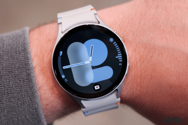 A close -up shot of a white smartwatch on a person 's wrist, displaying a blue and grey watch face.