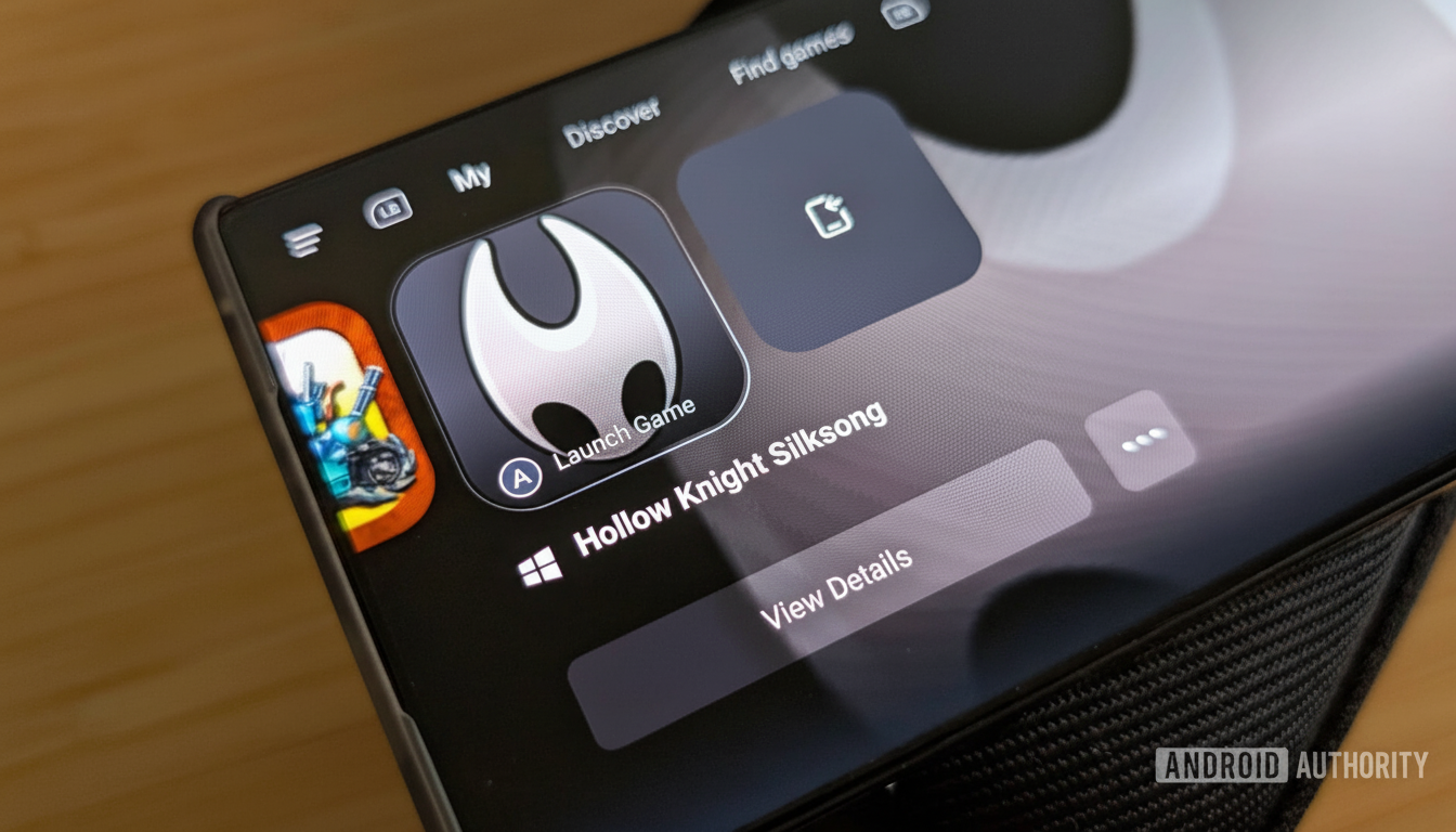 A close-up shot of a smartphone screen displaying the Xbox app, with the game Hollow Knight Silksong highlighted and options to Launch Game or View Details.