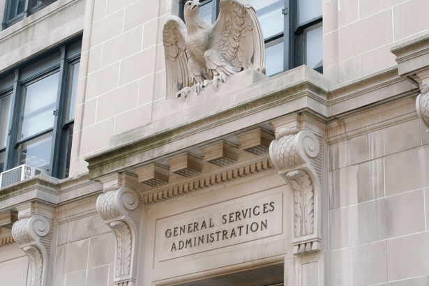 A detailed view of the General Services Administration building facade , featuring an eagle sculpture above the entrance and ornate architectural details .