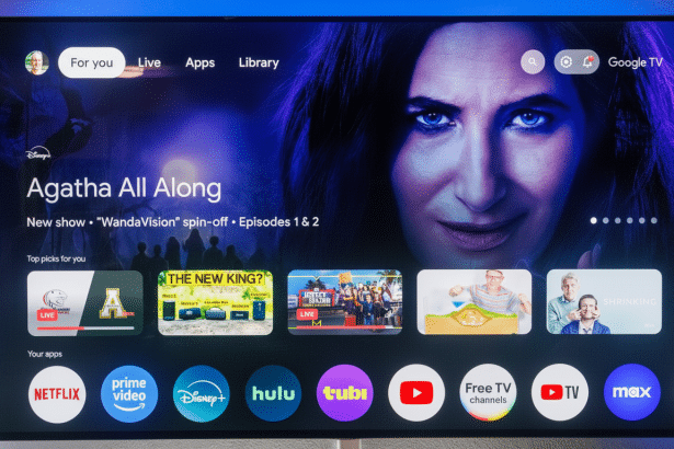 A modern television screen displaying the Google TV interface with various streaming apps and show recommendations, including Agatha All Along prominently featured. Filename : googletv interface1 6x 9. png