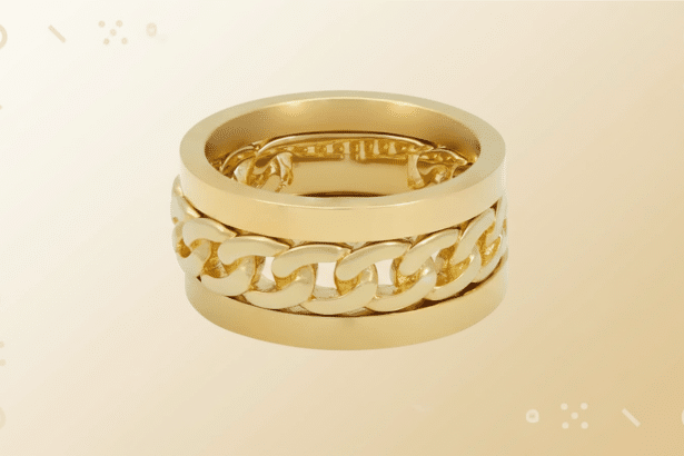 A professional shot of a gold ring featuring a central chain link design, resized to a 1 6: 9 aspect ratio with a soft, gradient background.