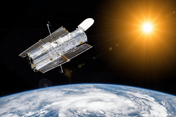 The Hubble Space Telescope orbits above Earth with a bright sunburst in the background.