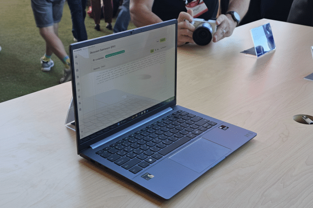 A blue - gray laptop displayed on a light wooden table, with a document summarizer application open on its screen.