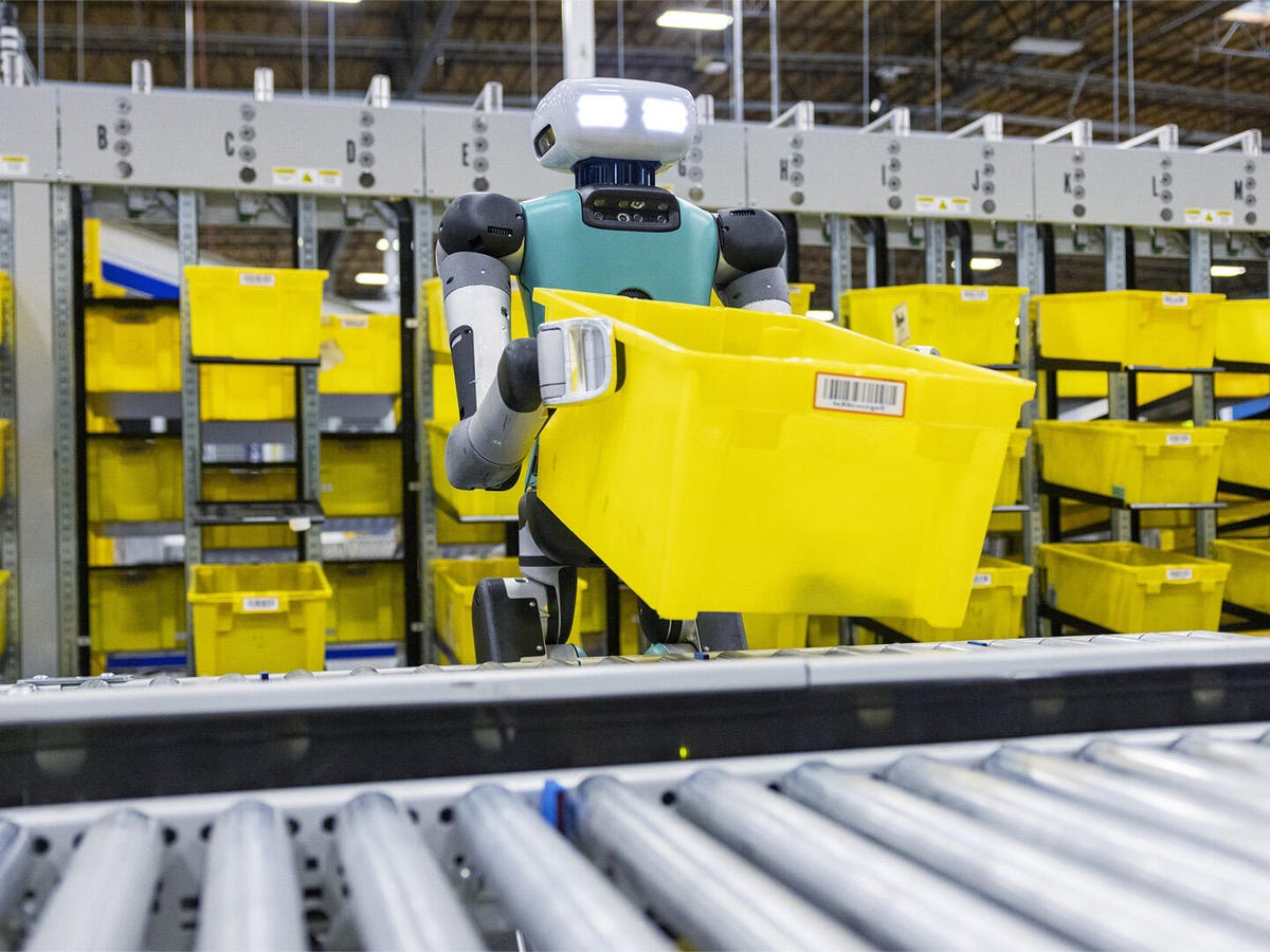 Robotic arms sorting packages in an Amazon warehouse, illustrating automation technology