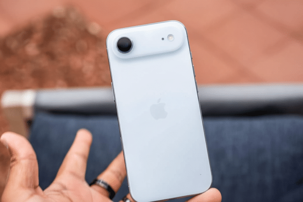 An off -white smartphone with a black camera lens and a small white sensor is held in a person s ha