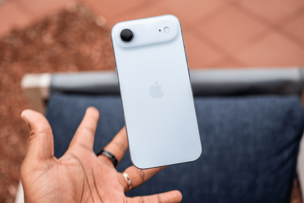 A hand holding a white iPhone with a single camera on the back, presented in a 16 :9 aspect ratio .