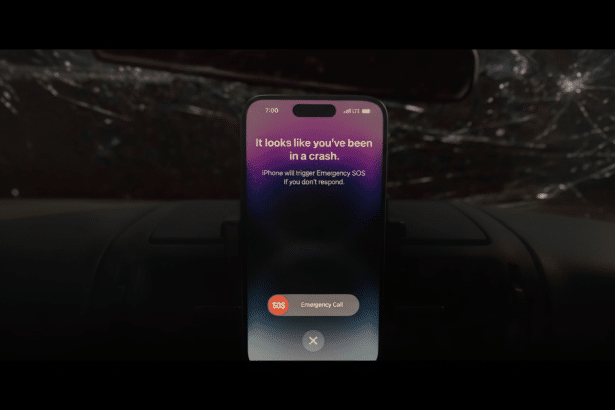An iPhone displaying a crash detection alert, offering to trigger Emergency SOS or make an emergency call , set against a dark, implied car interior with a shattered windshield in the background.