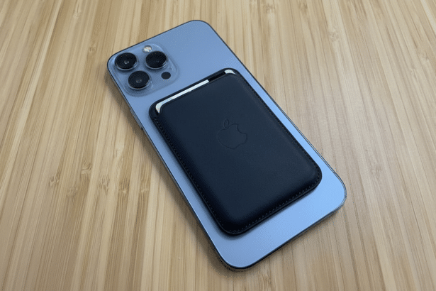 An iPhone with a MagSafe wallet attached, placed on a wooden surface.