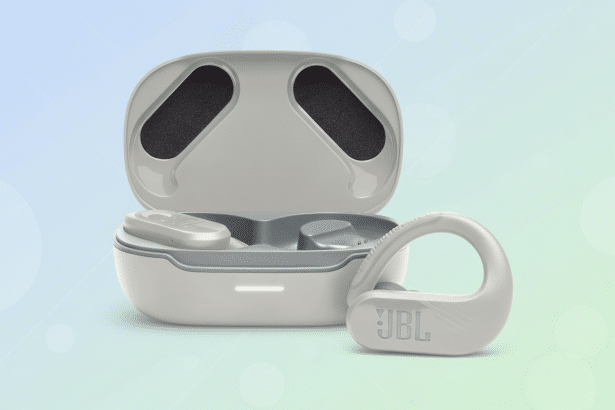 A professional 16:9 image of JBL Endurance Peak 3 earbuds and their charging case. The earbuds and case are light gray, with the JBL logo visible on one ear bud. The background is a soft gradient of light blue and green with subtle circular patterns. Filename : jbl endurancepeak 3ear buds. png