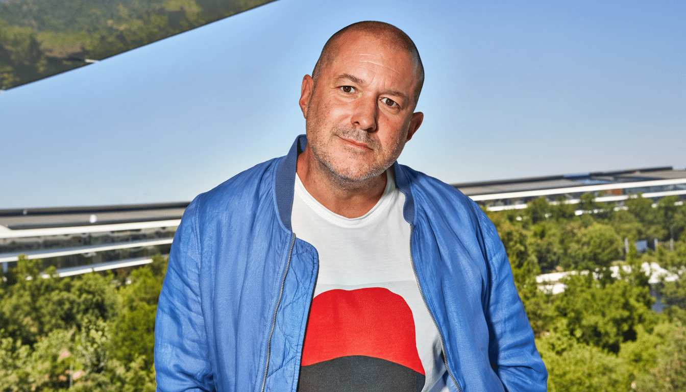 Jony Ive, former chief design officer of Apple, in a blue jacket and a white t -shirt with a red design.
