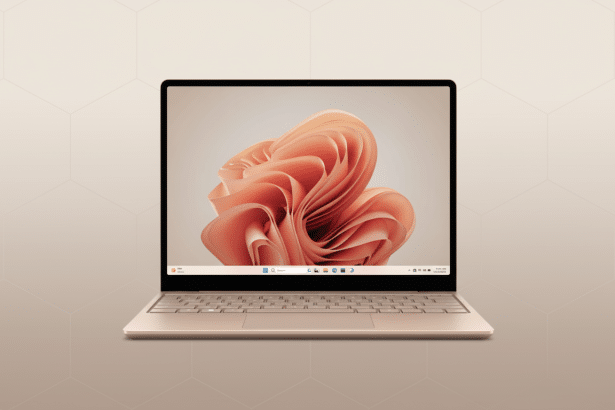 A professional shot of a modern , thin laptop with a gold -colored chassis and a vibrant peach- colored abstract wallpaper displayed on its screen. The background is a soft, light beige with a subtle geometric pattern, presenting the laptop in a clean and elegant manner. Filename : laptopgold geometric background .png