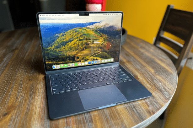 A modern laptop with a scenic desktop background, placed on a wooden table .