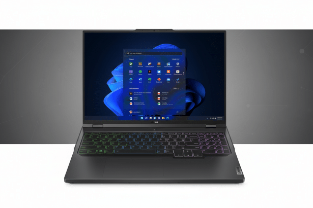 A Lenovo Legion gaming laptop with its screen displaying the Windows 11 start menu on a grey background with subtle geometric patterns. Filename : lenovo legionlaptop windows 1 1.png