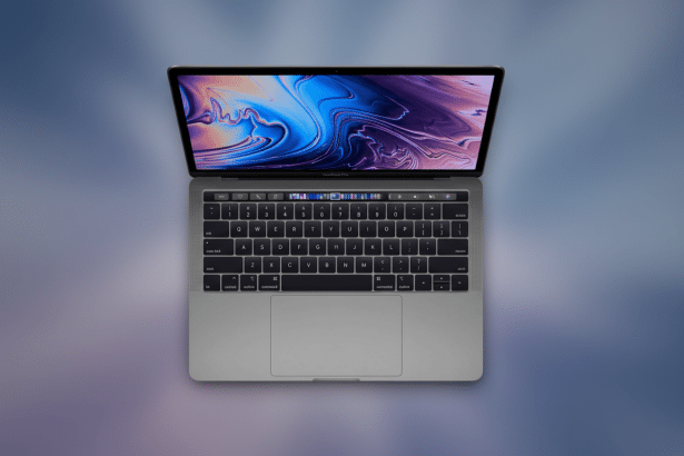 A silver MacBook Pro with its screen displaying a vibrant , abstract purple and blue wallpaper , set against a blurred background with soft purple and blue gradients.