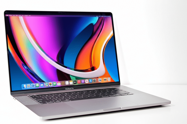 A professional shot of a silver MacBook Pro with a vibrant, colorful wallpaper displayed on its screen.