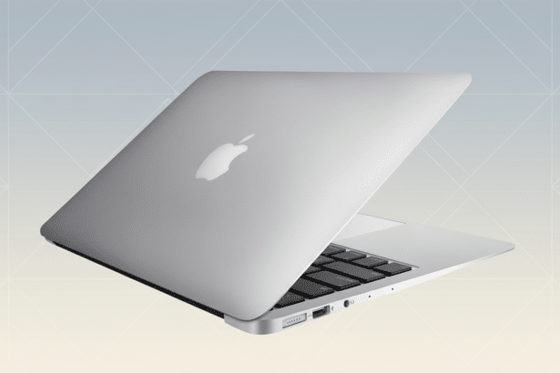 A silver Apple MacBook Air laptop shown at an angle, with the lid slightly open, on a soft gradient background with subtle geometric patterns.
