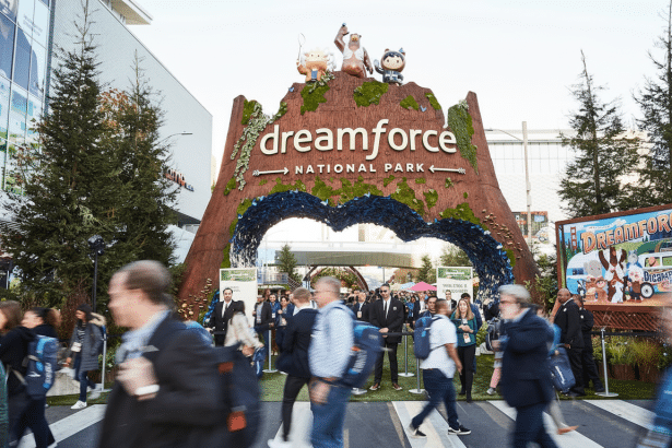 A large Dream force National Park entrance structure with cartoon characters on top, surrounded by attendees.
