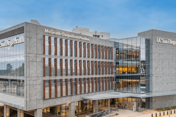 The McGrath Outpatient Pavilion , a modern multi -story building with a concrete and glass facade, under a clear sky . The building features signage for UCSan Diego Health and Mc Grath Outpatient Pavilion. Filename : mcgrath outpatient pavilion1 6 9.png